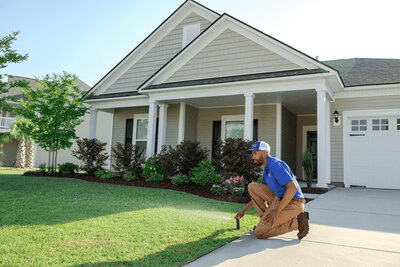Conserva Irrigation tech adjusting sprinkler head in driveway